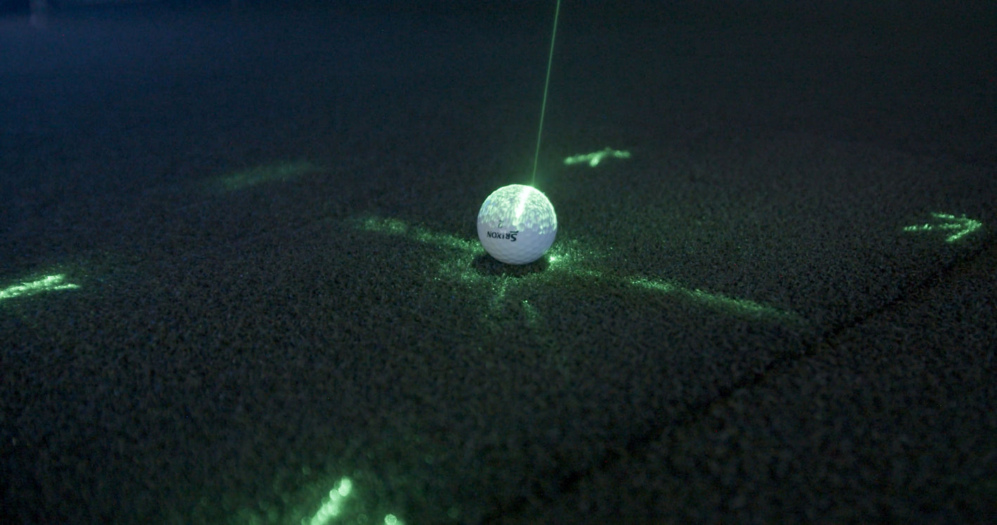 Golf ball on simulator turf with laser tracking system measuring position and spin